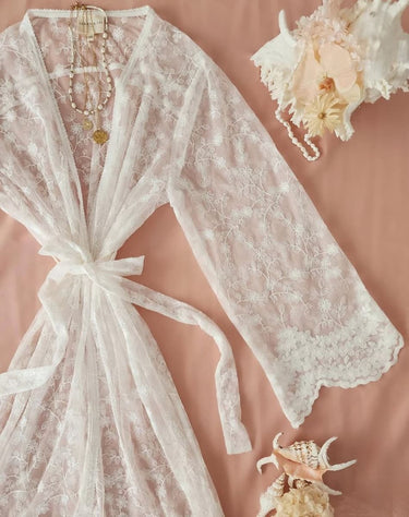Lace robe with floral decorations on a soft pink background